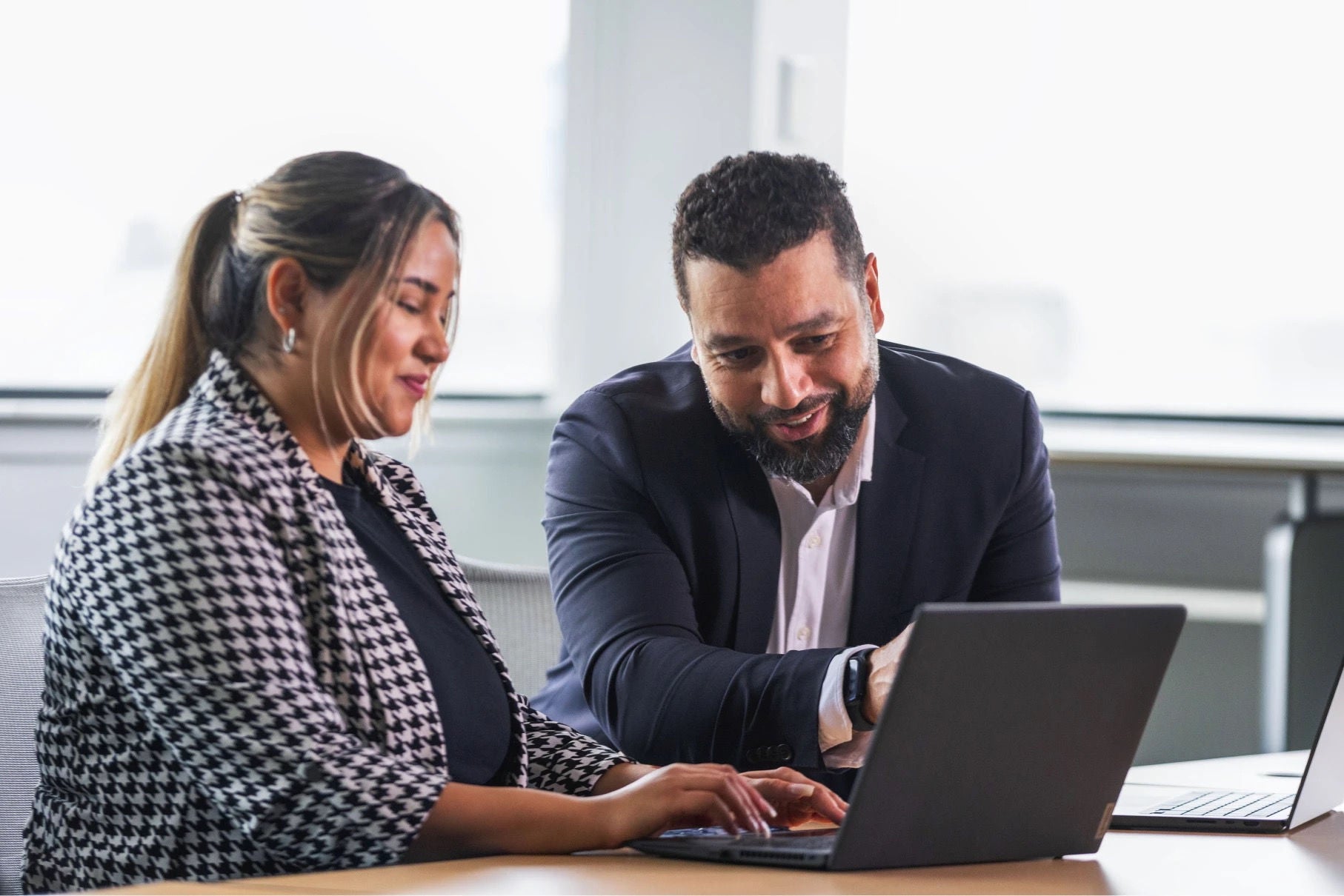 Two coworkers working together at a laptop computer
