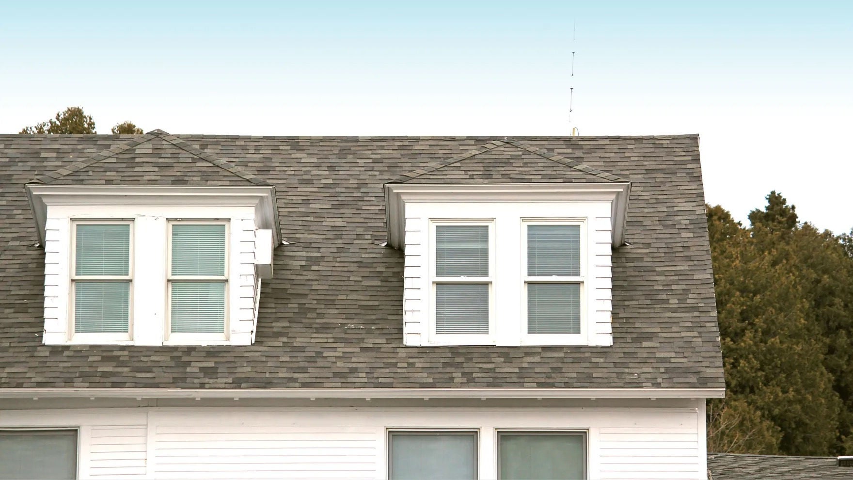 Two dormer windows and grey shingles on a section of the Island House Hotel roof