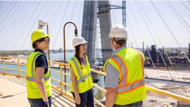 Construction workers in hardhats and reflective gear on a jobsite