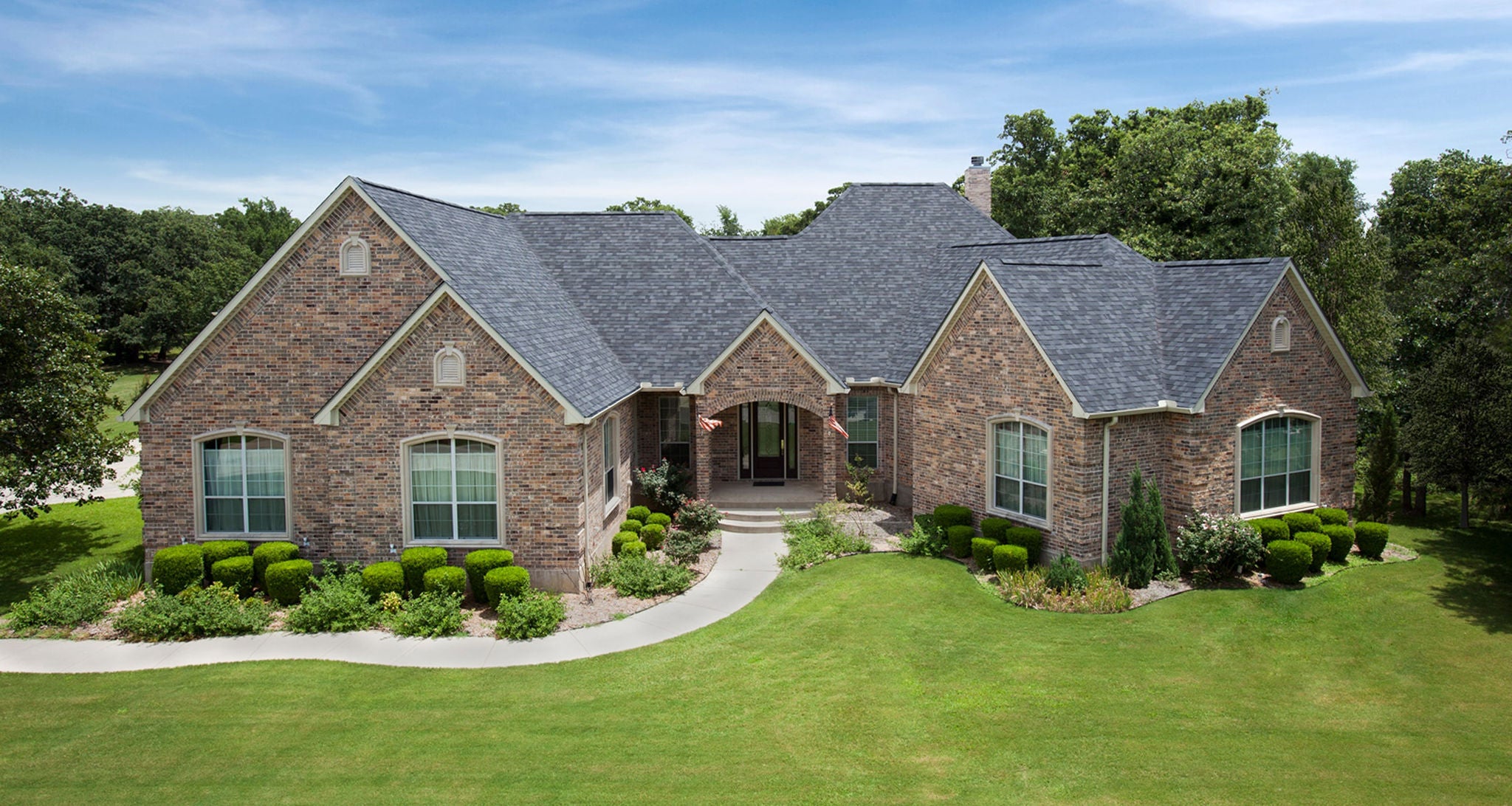 Aerial view of modern, upscale suburban house with grey shingle roof