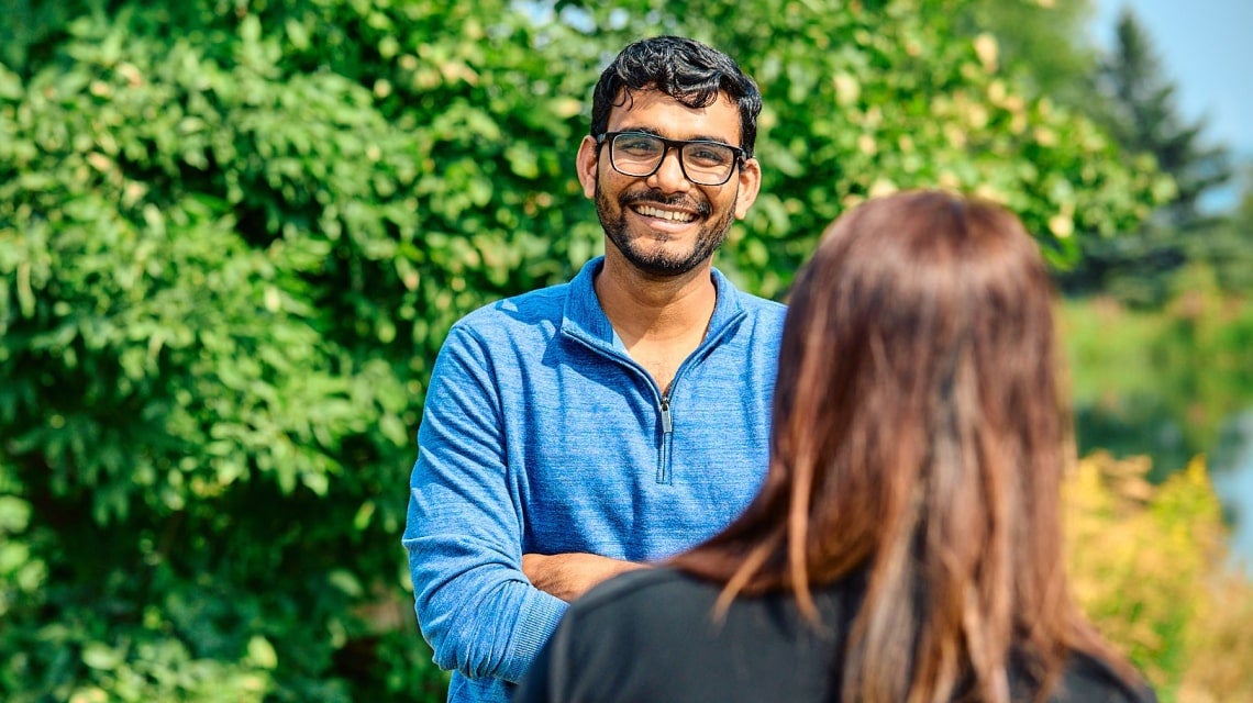 Two coworkers having a friendly conversation outside on a sunny day